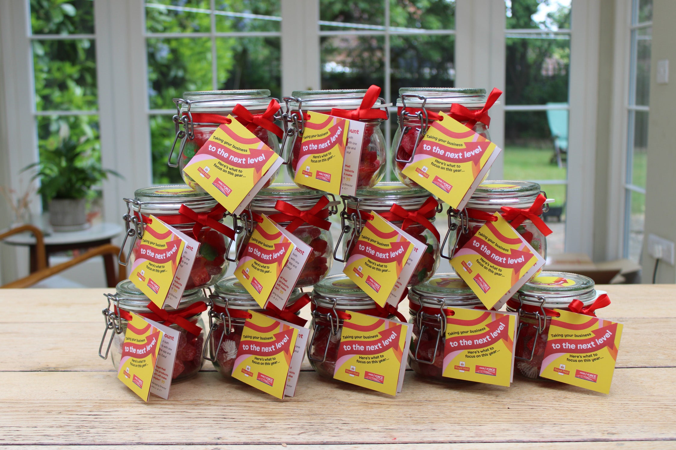 Jars with red ribbons and yellow labels on a wooden table