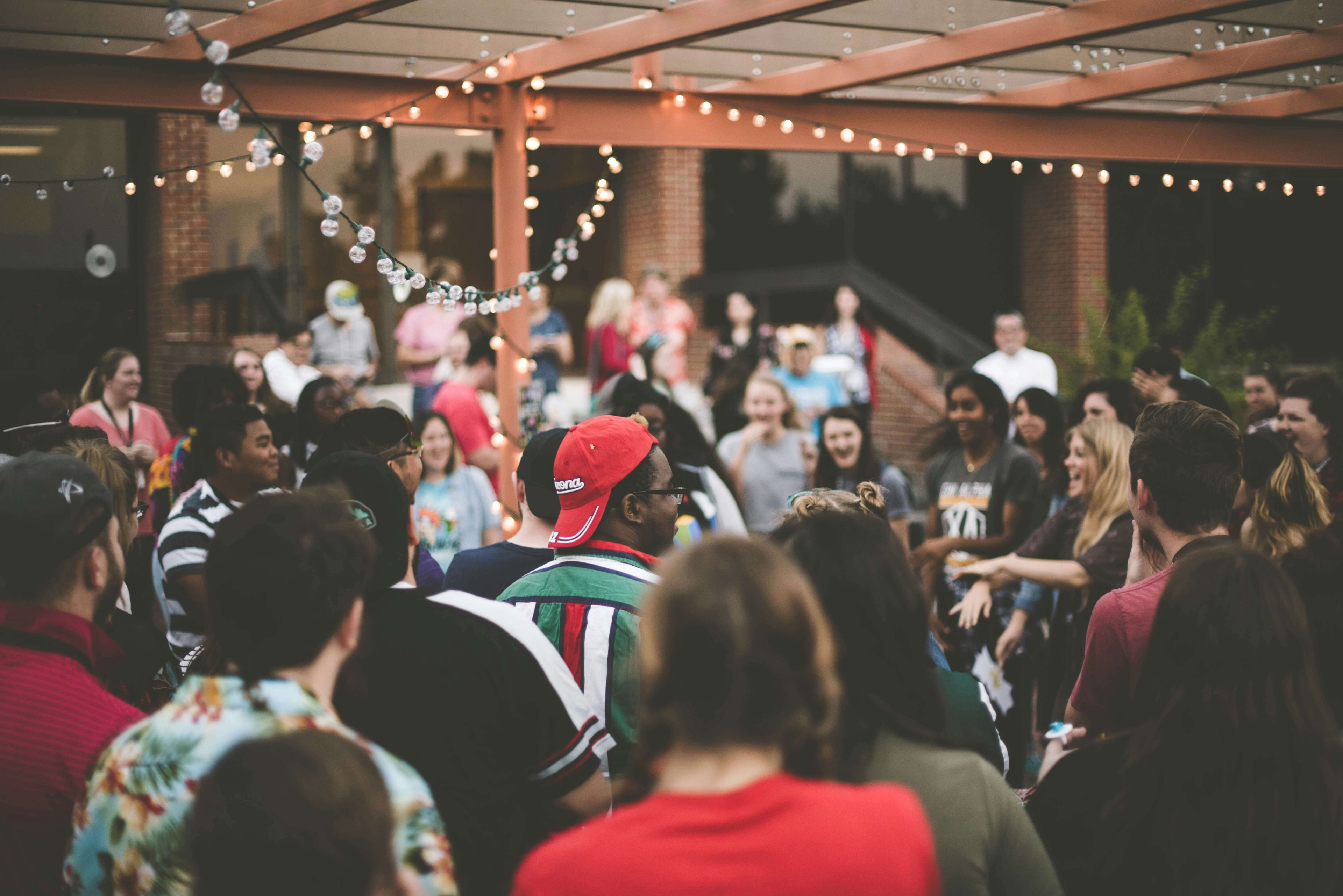 Group of people gathered outdoors under string lights